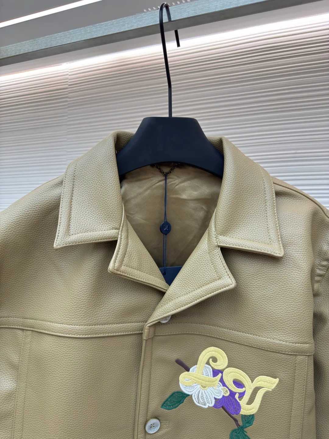 LOUIS VUITTON Tunic Jacket ●Authentic product: Purchased and developed by 50050 ●Item number: 1680165-C00 ●Fabric: Leather fabric ●Technology: Positioning cutting machine ●Version: Fitted version ●Weight: about 1365 grams ●Size: 50-52-54-56 ●Description: 24ss new tunic jacket has the retro connotation of gorgeous grain leather, with LV Flower Embroidery interprets seasonal tropical island elements. Marque L. Vuitton déposée leather patch sits at the back, and pearlescent buttons add a chic touch. The overall workmanship is very complicated. The embroidery is made with heat-capacitive glue, which needs to be ironed to ensure quality. The checkerboard pattern needs to be positioned correctly, so it is very fast. Each process of the entire garment is slow and time-consuming.